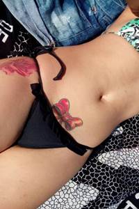 Novinha deliciosa com tatuagens na buceta ficou batendo fotos pelada